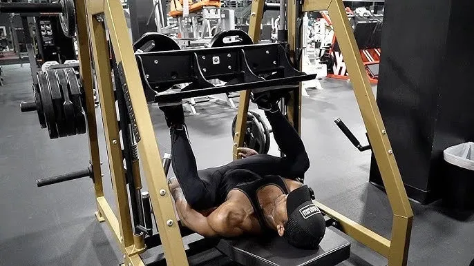 Người tập sử dụng máy leg press đứng trong không gian phòng gym hiện đại với tư thế đẩy tạ thẳng đứng