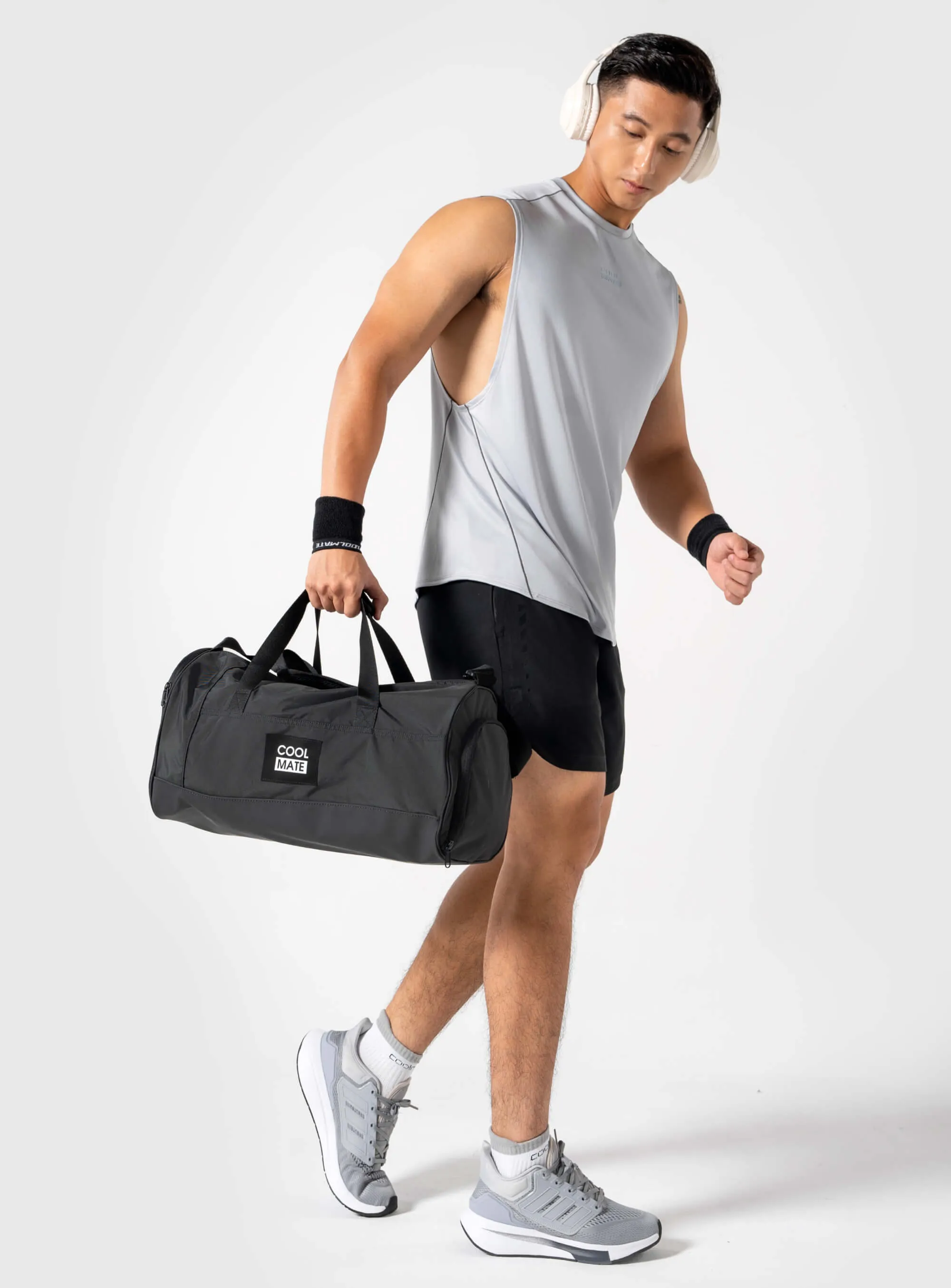 Người mẫu cầm túi trống tập gym Coolmate màu đen, phối đồ thể thao.
